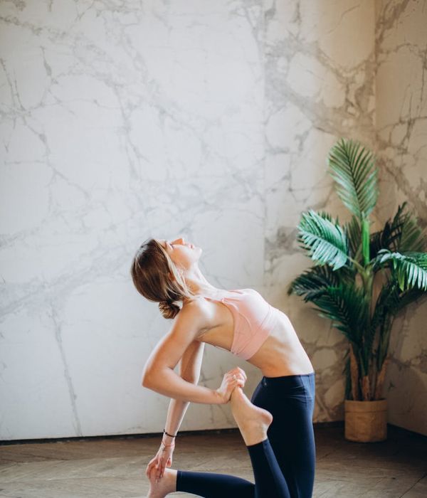 Person in a balancing yoga pose in a bright, modern studio.